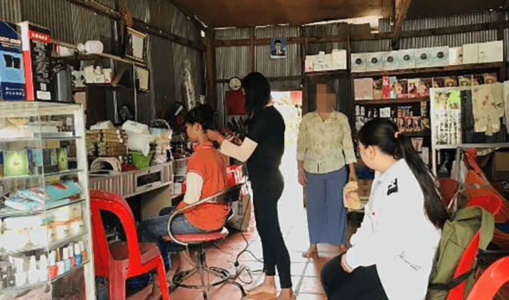 Kannareth, a caseworker in Cambodia, visits a survivor during her salon training