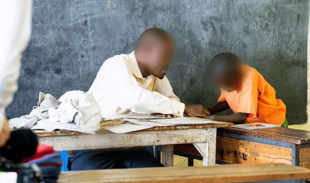 Michael assists a student in his classroom